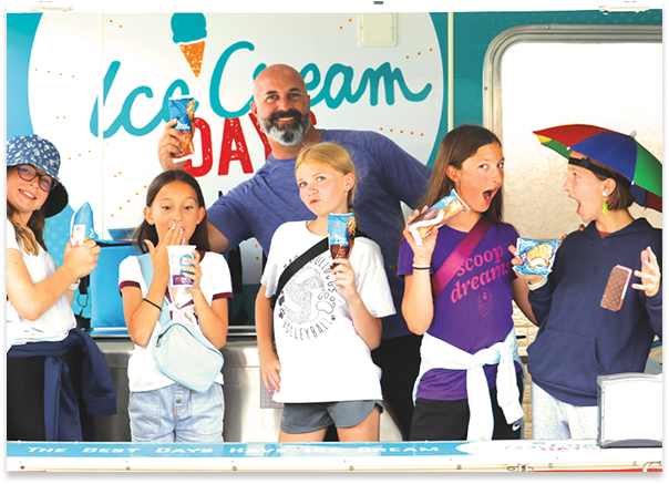 Family posing for a photo during Ice Cream Days holding ice cream treats