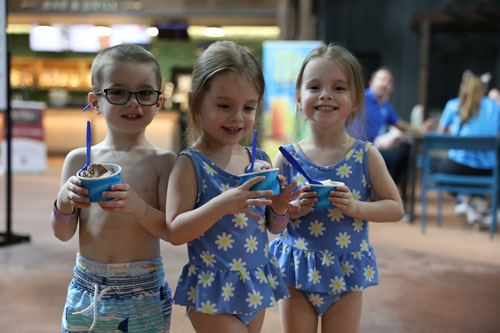 Three kids smiling and holding their ice cream