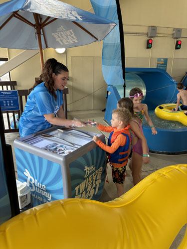 Woman giving ice cream to children
