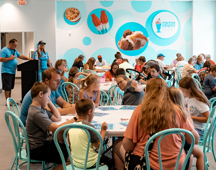 Lots of people sitting around tables at the parlor